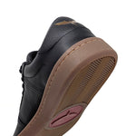 Load image into Gallery viewer, Close-up of the heel and side of the black leather Icarus Ascent barefoot sneaker with a gum sole and metallic gold logo on the heel, shown on a white background.
